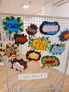 Ein Gitter mit bunten, comicartigen Sprechblasen, die verschiedene Wörter und Ausrufe wie 