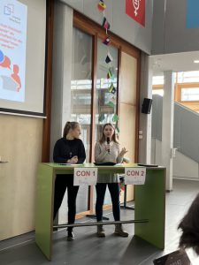 Zwei Frauen stehen an einem Tisch mit der Aufschrift 